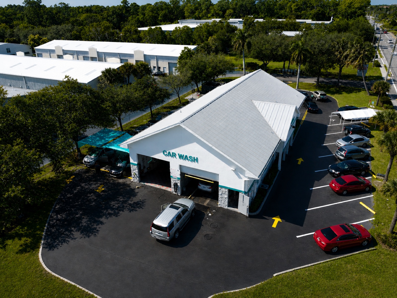 Aerial view of Radio Road Car Wash facility at 4790 Radio Rd Naples FL with white building, blue roof, and surrounding parking lot.